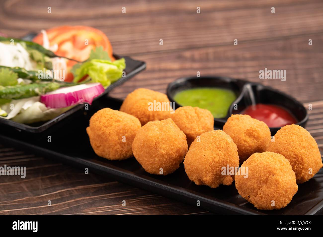 Indian Delhi Street Chaat Food Ram Laddu Pakode Or Raam Ladoo Pakore Is Made Of Moong Dal, Yellow Mung Lentils, Chana Daal. Served With White Radish Stock Photo