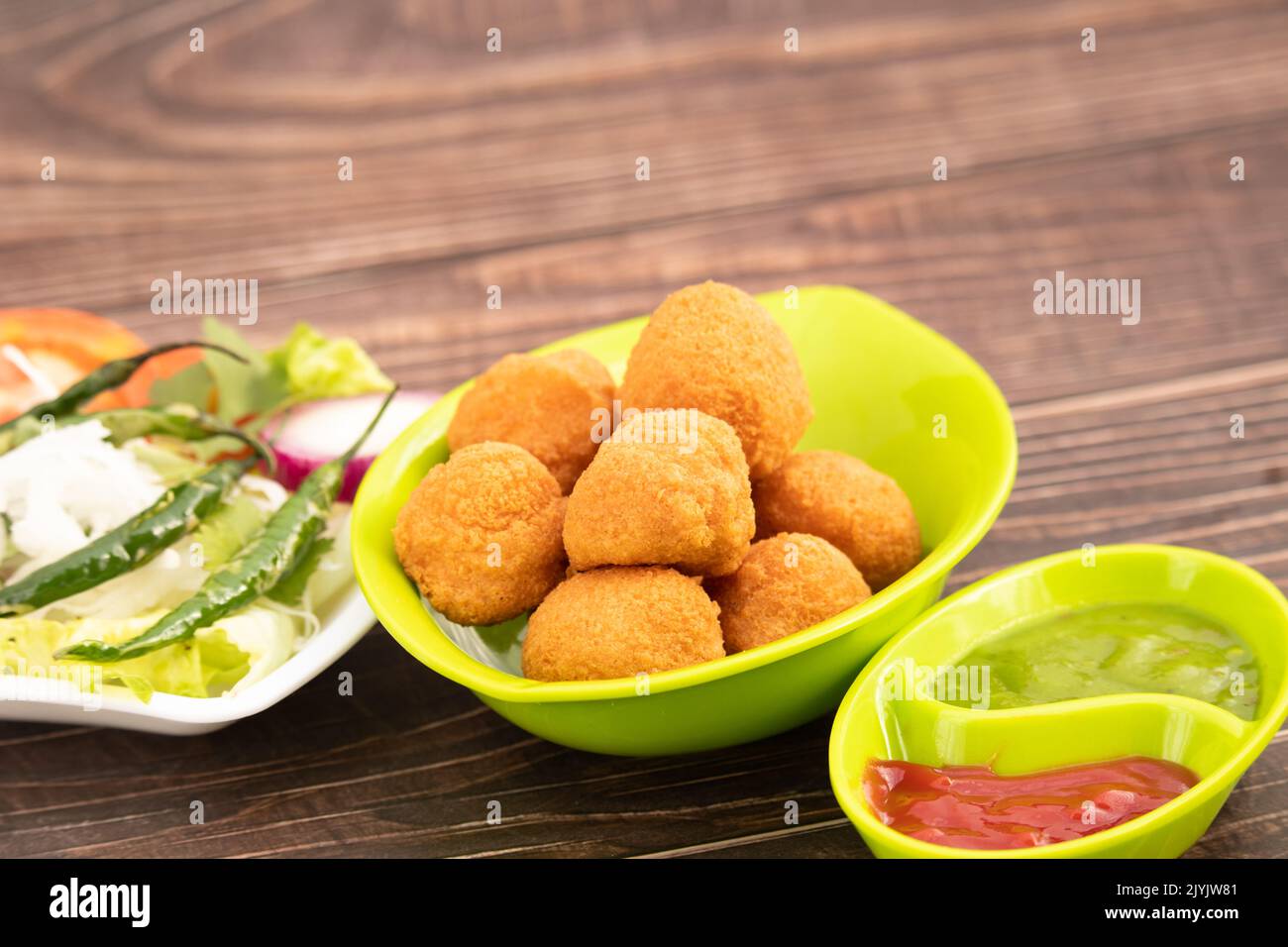 Indian Delhi Street Chaat Food Ram Laddu Pakode Or Raam Ladoo Pakore Is Made Of Moong Dal, Yellow Mung Lentils, Chana Daal. Served With White Radish Stock Photo