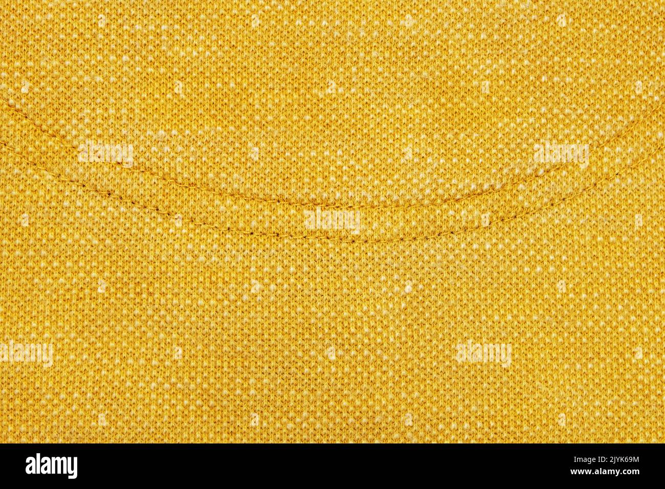 Close up of yellow stitching detail on fabric. The stitching is in the shape of a curve Stock Photo