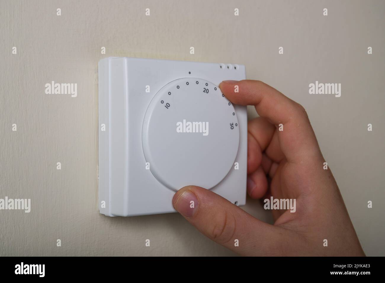Turning down the central heating thermostat to save energy and reduce