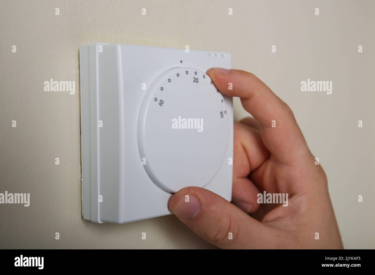 Turning down the central heating thermostat to save energy and reduce bills in the UK Stock Photo