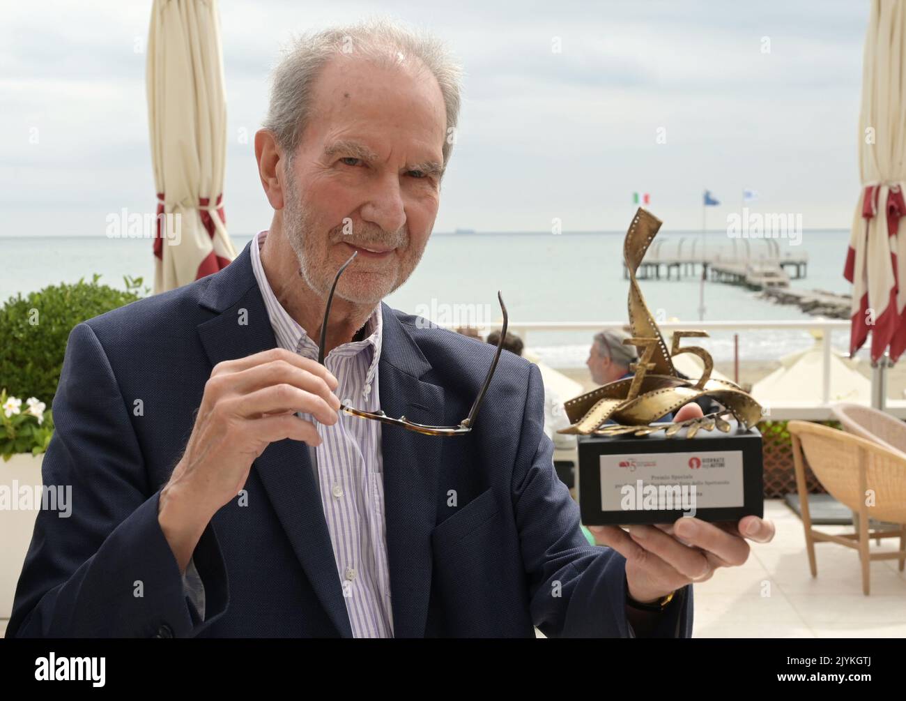 08 September 2022, Italy, Venedig: German director Edgar Reitz, known for his "Heimat" series of films, stands on the terrace of the Hotel Excelsior showing his special lifetime achievement award received from the 75° Fondazione Ente del Spettacolo and Giornate degli Autori during the 79th Venice International Film Festival. (to dpa: "Director Edgar Reitz: Home is no longer a fixed place") Photo: Stefanie Rex/dpa Stock Photo