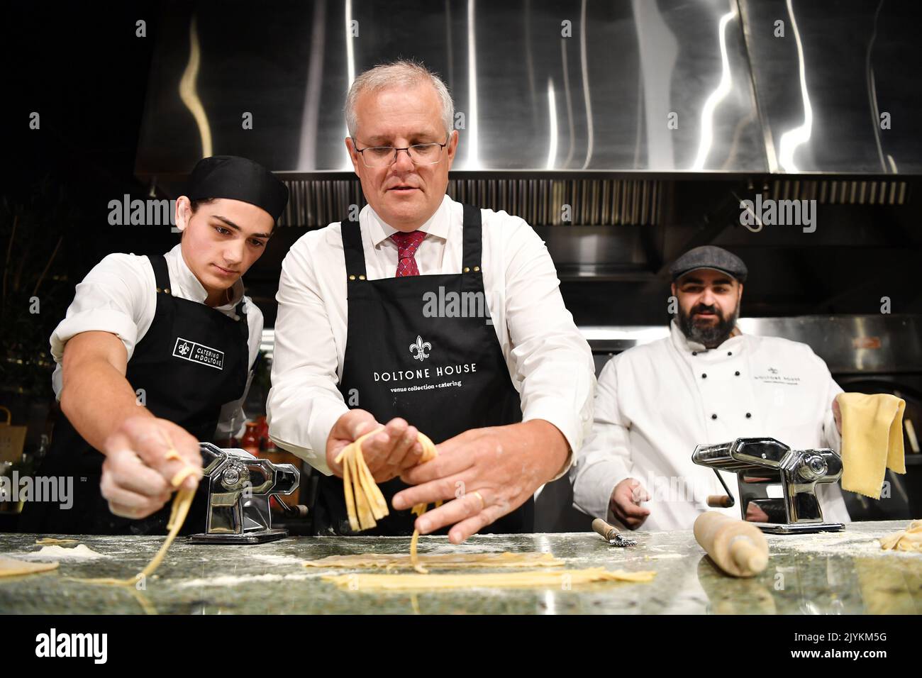 Prime Minister Scott Morrison (centre) is taught to make pasta by