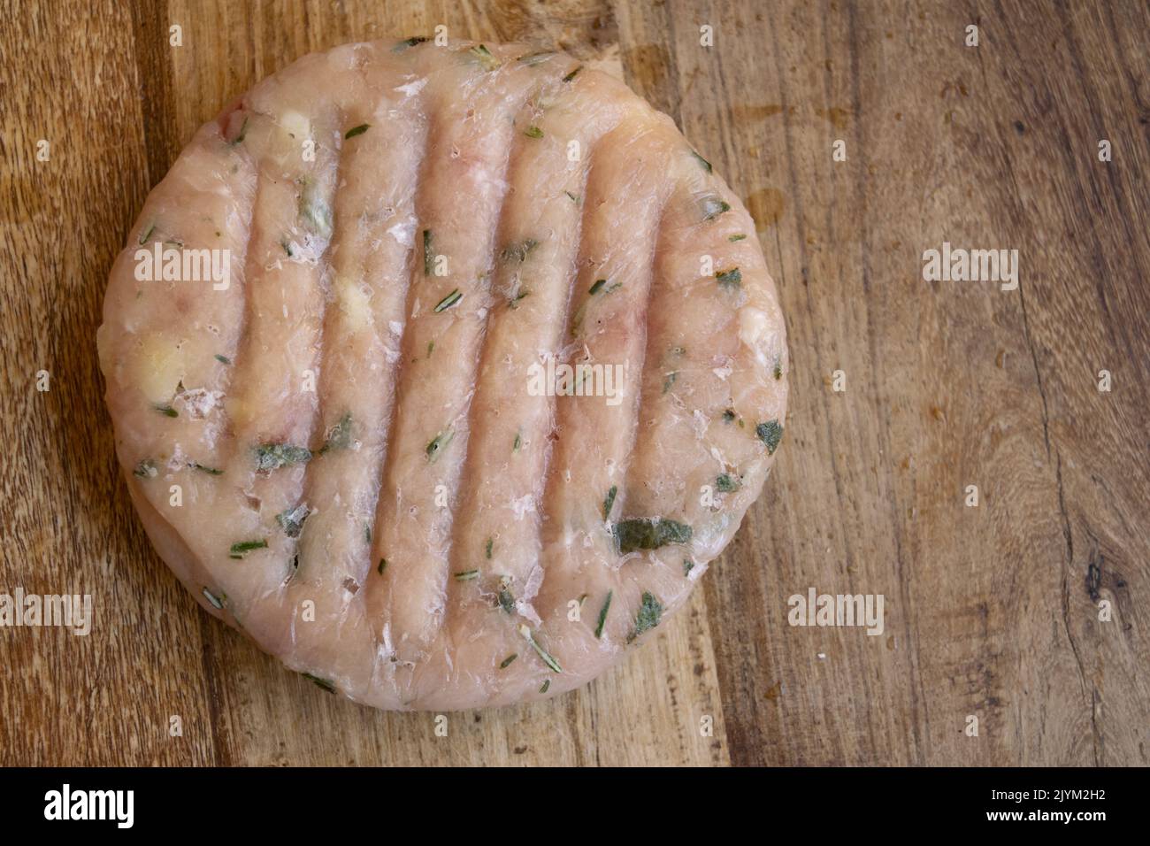 frozen chicken hamburger made at home flavored with herbs Stock Photo