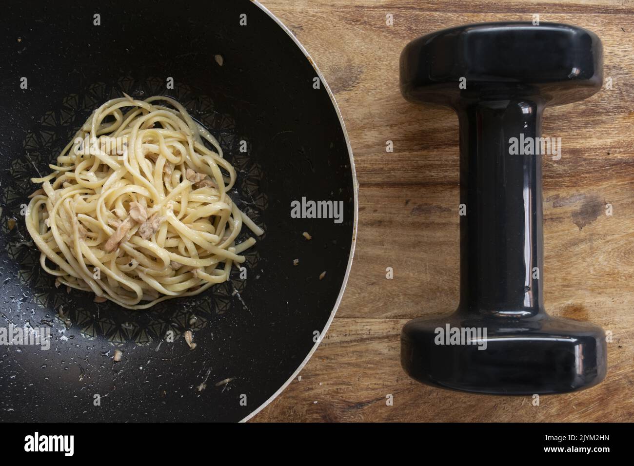 concept of food and sporting activity with a dumbbell and a dish of