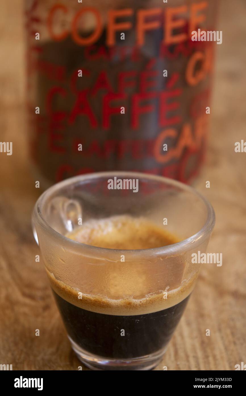 coffee in glass cup with in background a jar with coffee word Stock Photo