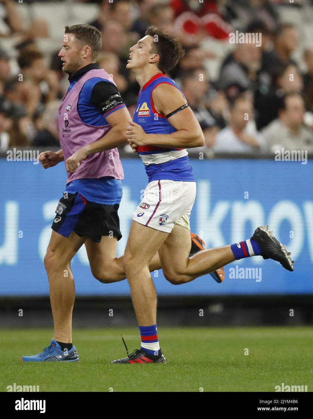 Laitham Vandermeer of the Bulldogs leaves the field with the trainer during  the Round 1 AFL match between the Collingwood Magpies and Western Bulldogs  at the MCG in Melbourne, Friday, March 19,