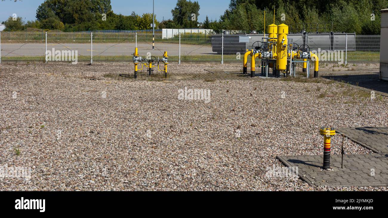 Yellow pipes and valves of natural gas transmission installations. The high price of the raw material is killing business. Photo taken on a sunny day Stock Photo