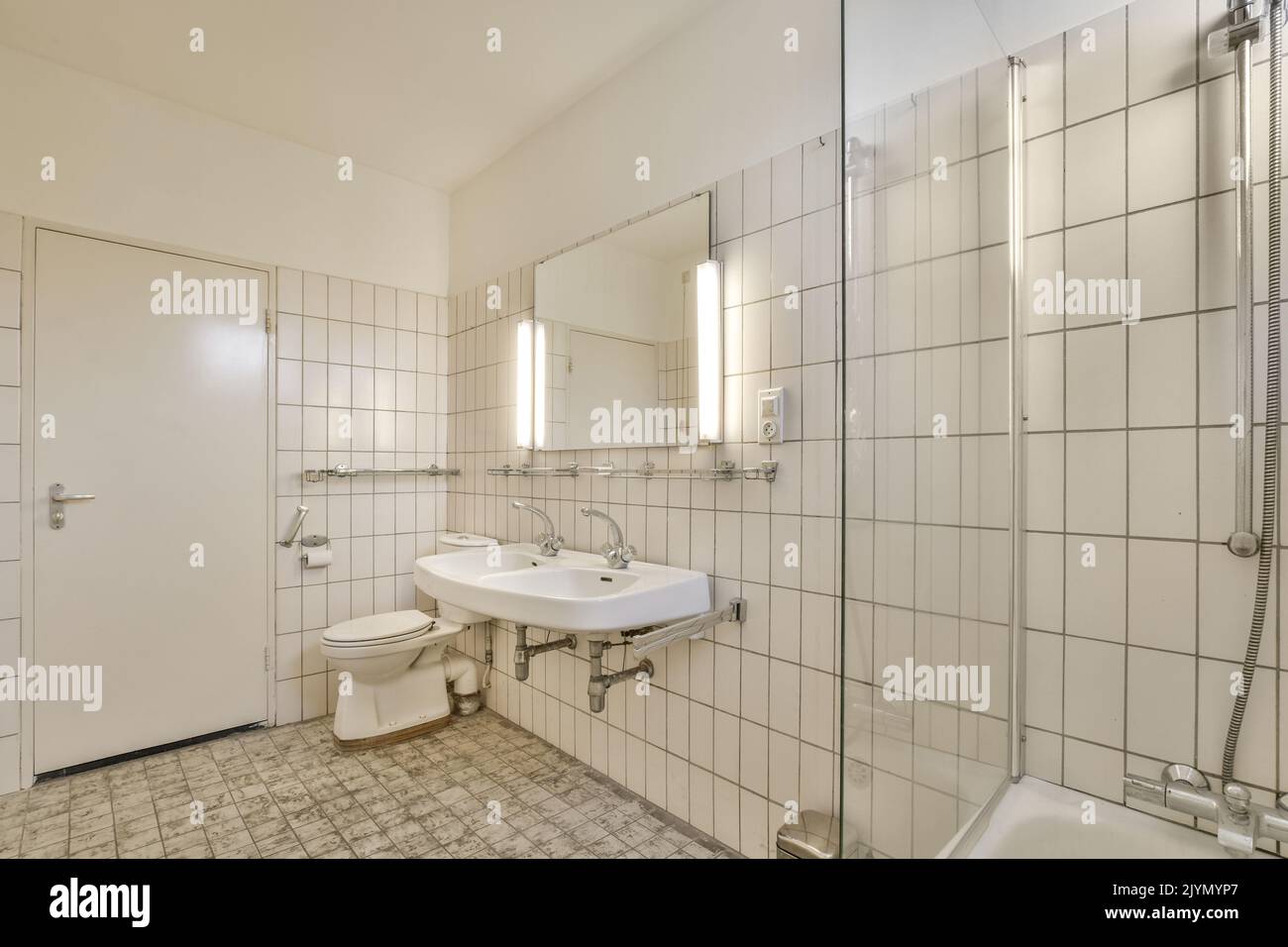 Bathroom with white tiled walls near sink in light Stock Photo