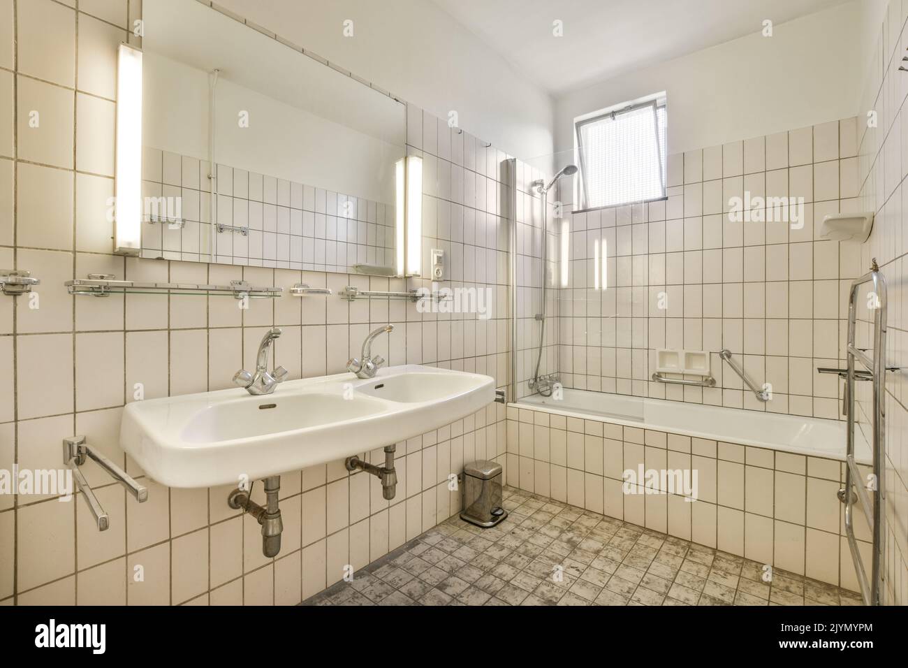 Bathroom with white tiled walls near sink in light Stock Photo