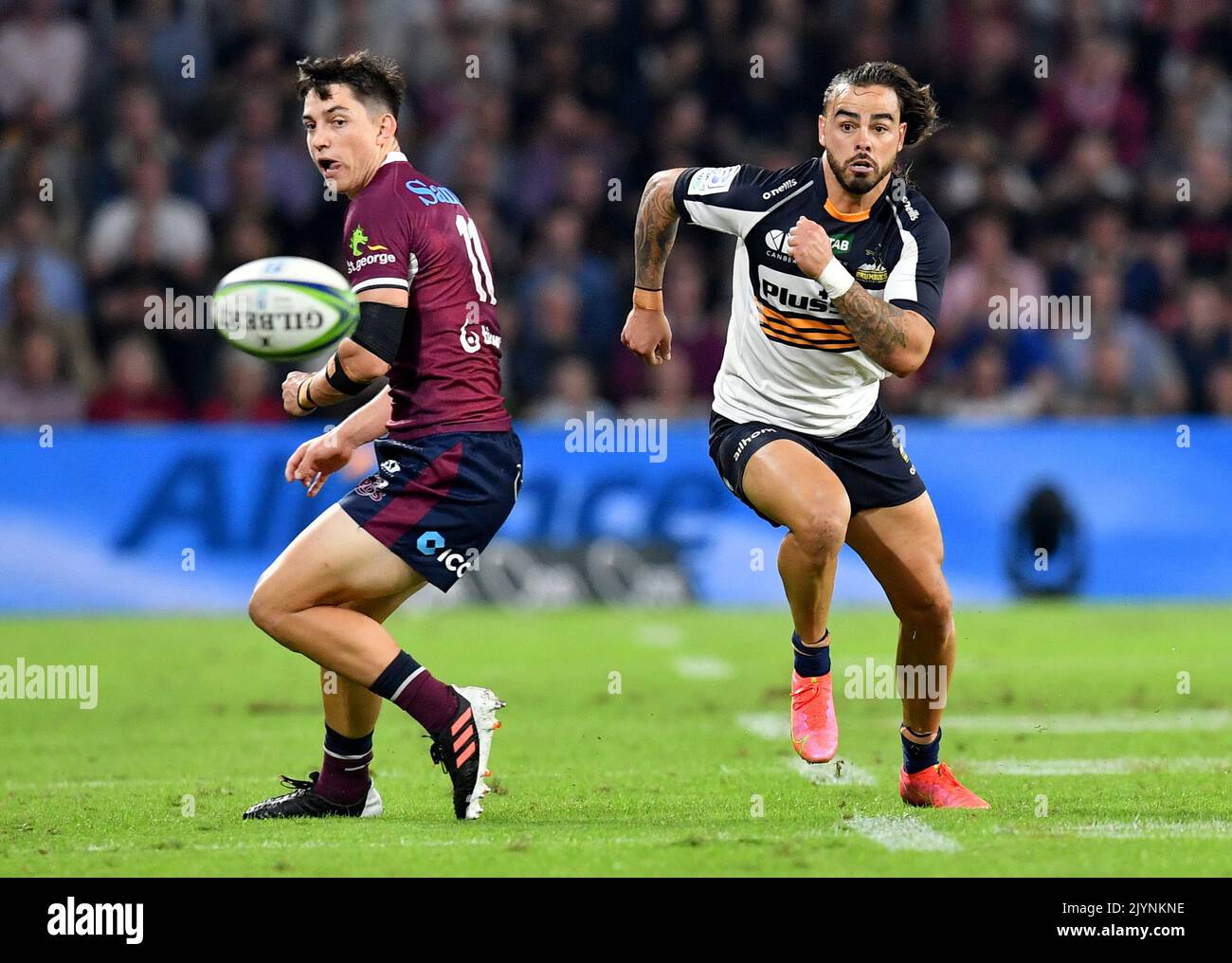 Andy Muirhead (right) of the Brumbies kicks past Jock Campbell (left ...