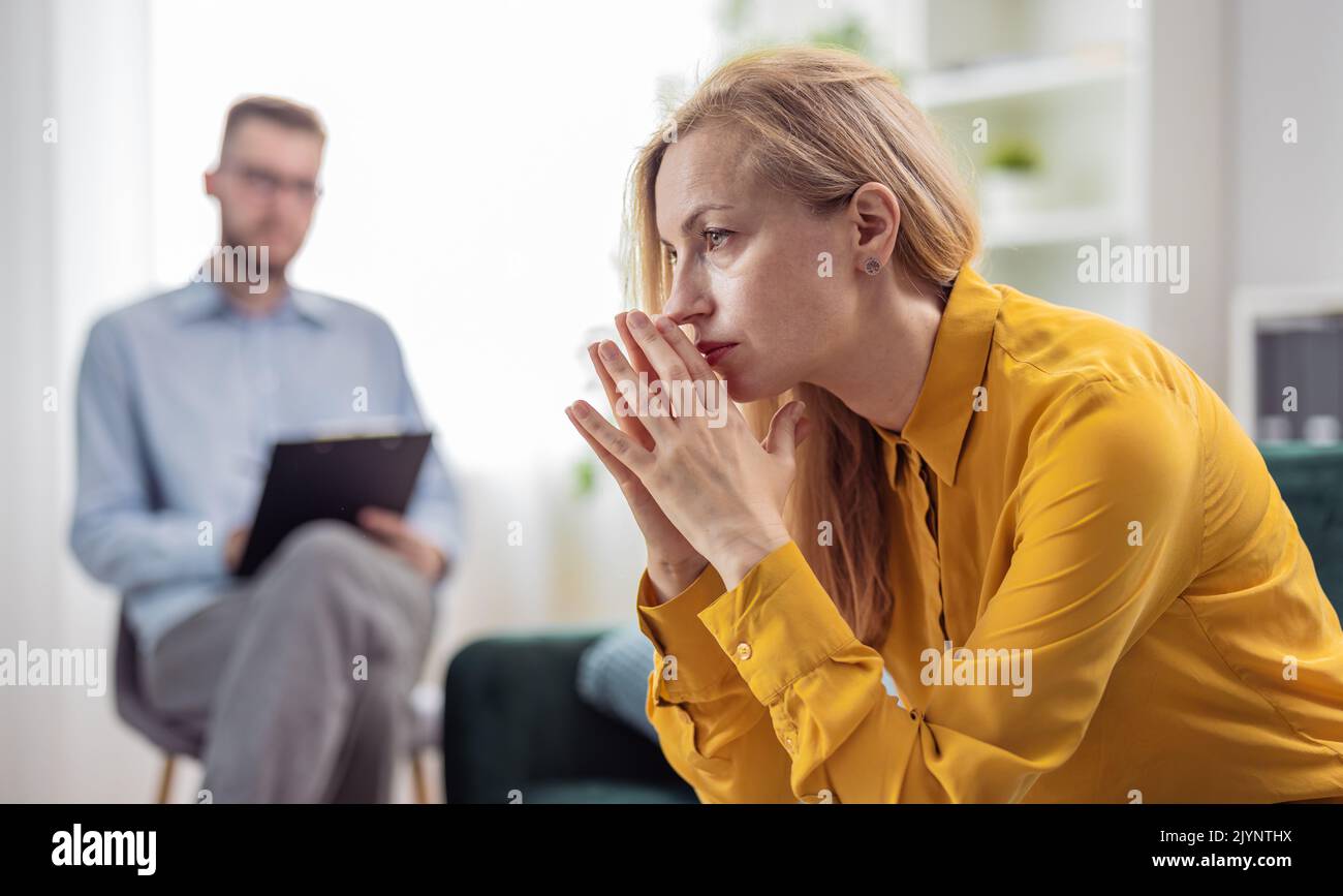 Worried woman at psychologist Stock Photo