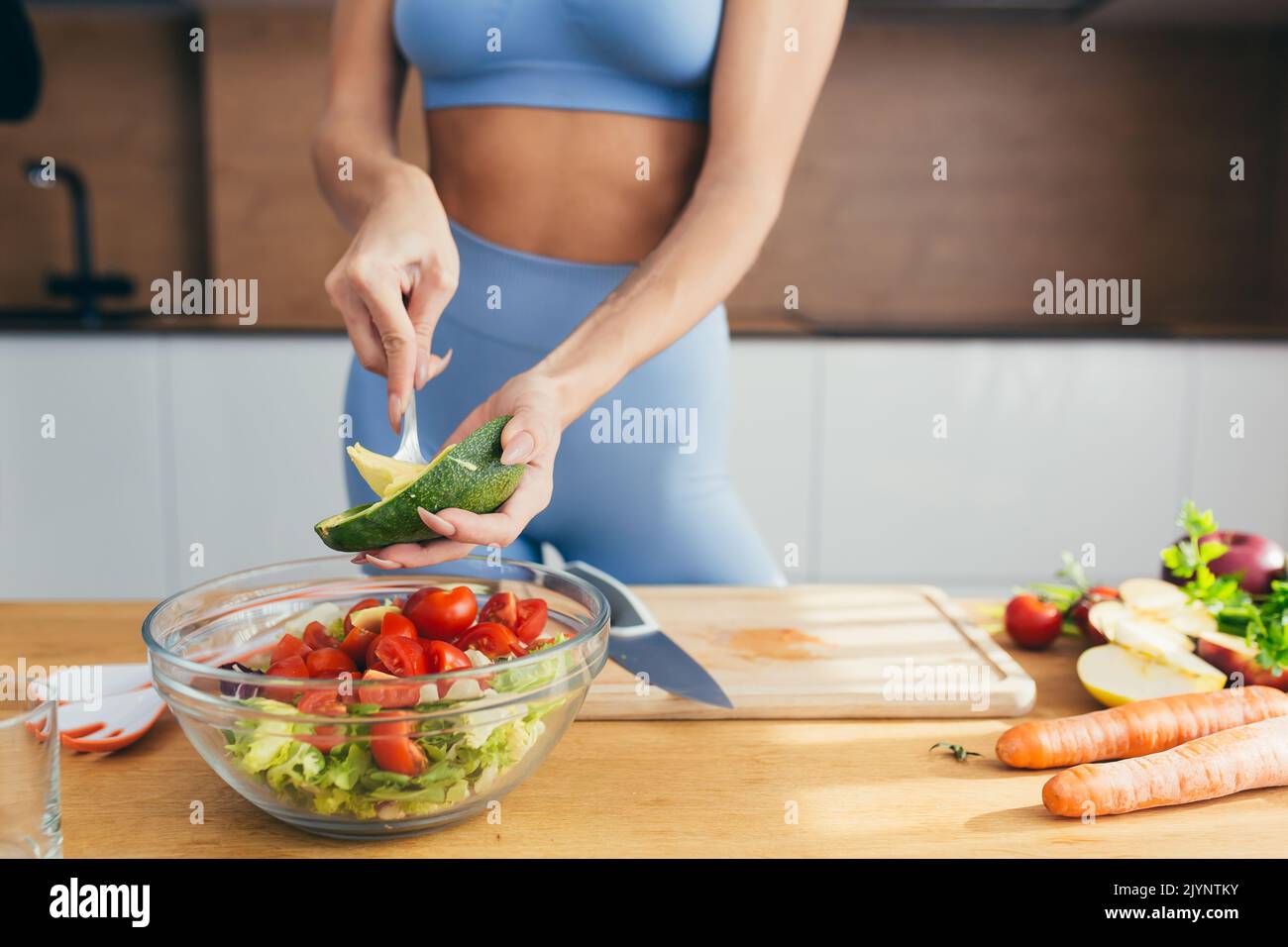 Close up photo, body part, hands of young fitness woman cutting fresh vegetables on kitchen salad at home Stock Photo