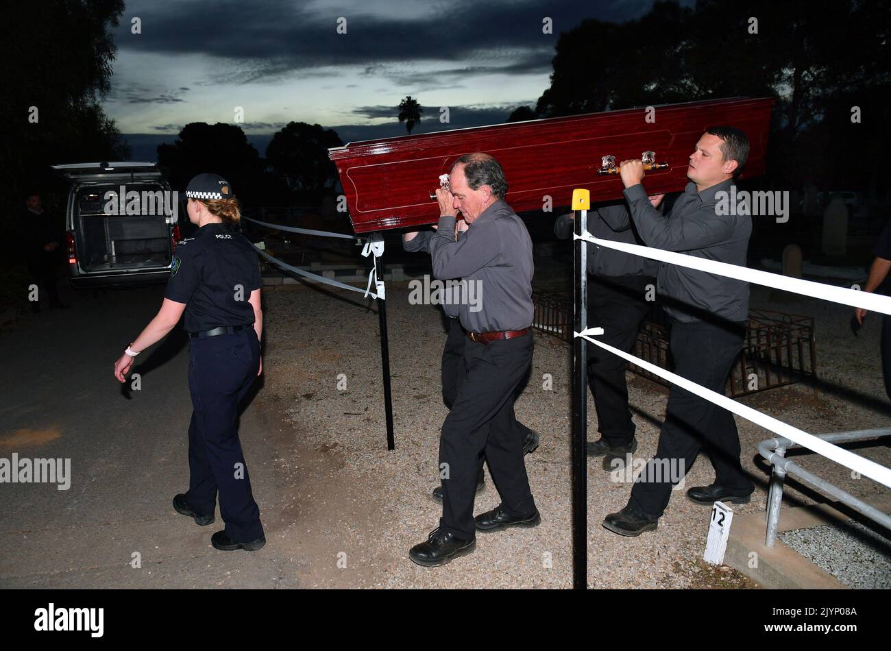 Adelaide Cemetery Authority pall bearers carry the body of the exhumed