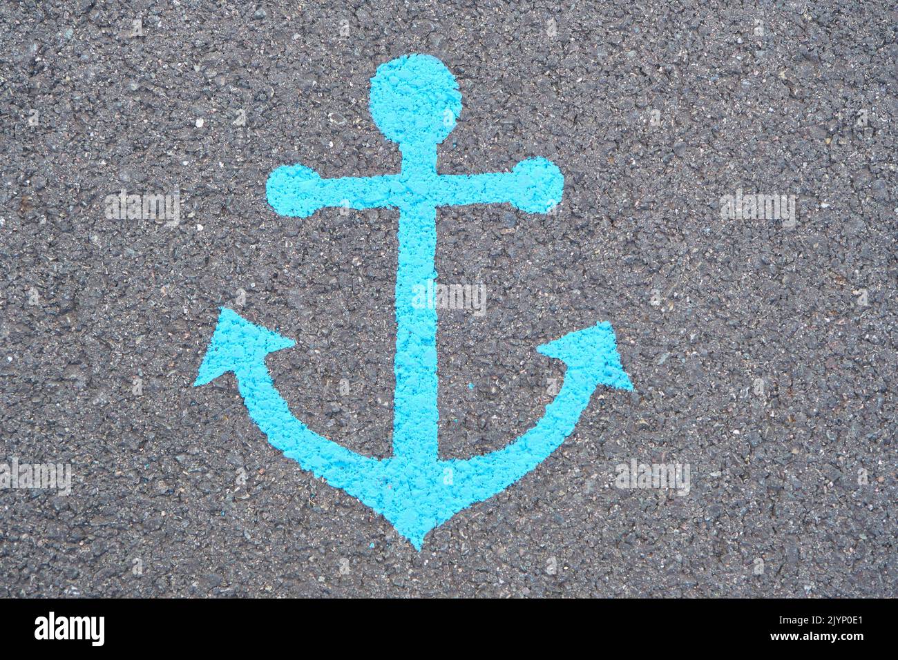 Image of an anchor painted in blue on a asphalt road at the Port of Sydney Nova Scotia. Stock Photo