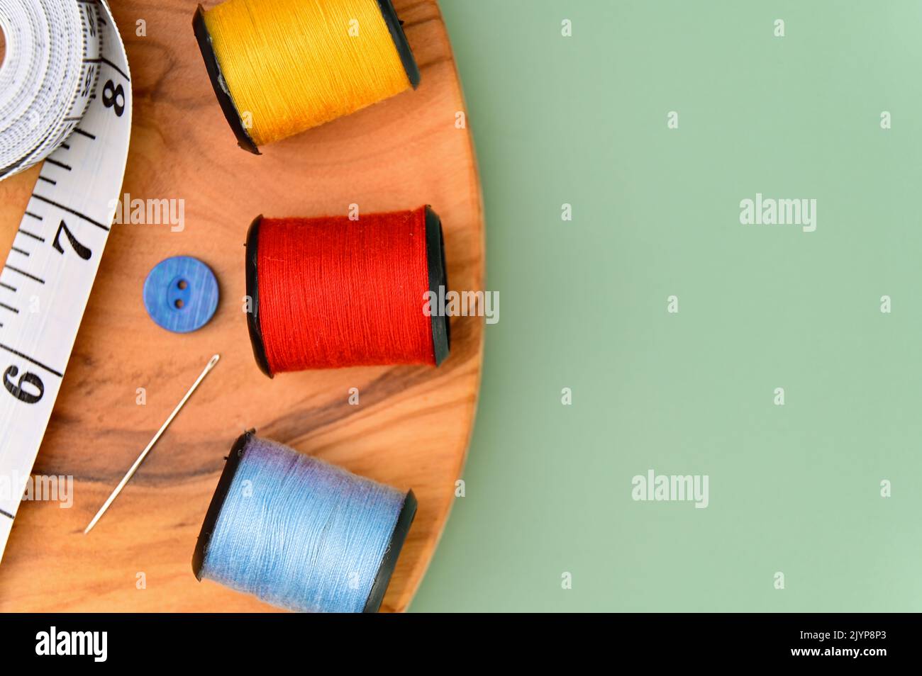 Sewing accessories and fabric on a green background. Including needle