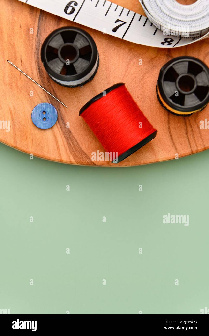 Sewing accessories and fabric on a green background. Including needle