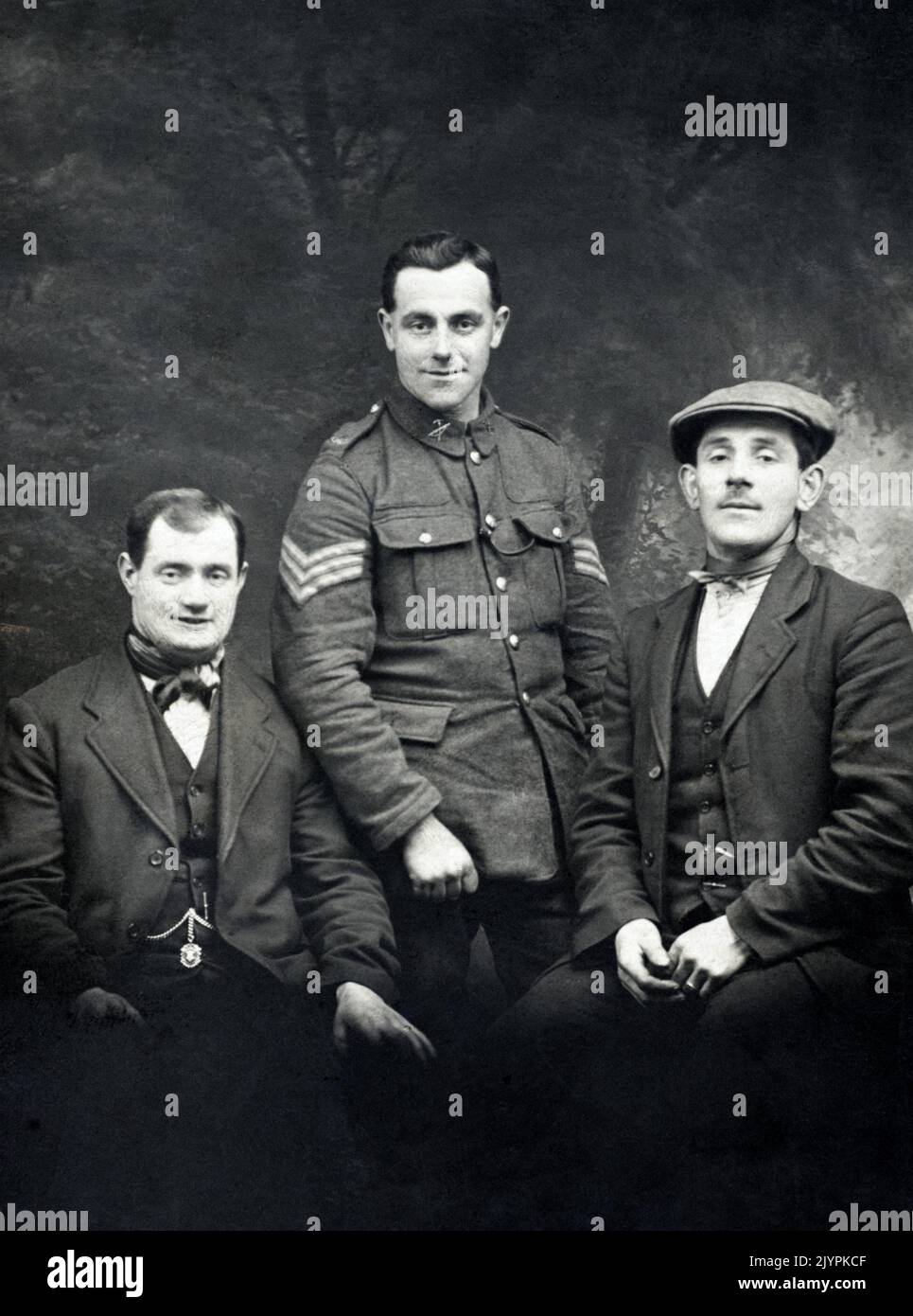 A portrait of a First World War British soldier, a sargeant in a Labour Battalion of an infantry regiment, alongside two civilians. Stock Photo