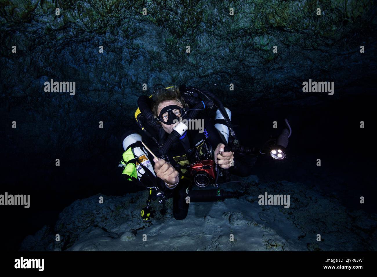 Rebreather diver. Diver who has just taken a piece of stalactite which was lying on the ground. This sample will allow us to know more about this cave and perhaps discover the date of its immersion. Underwater cave, Mayotte Stock Photo