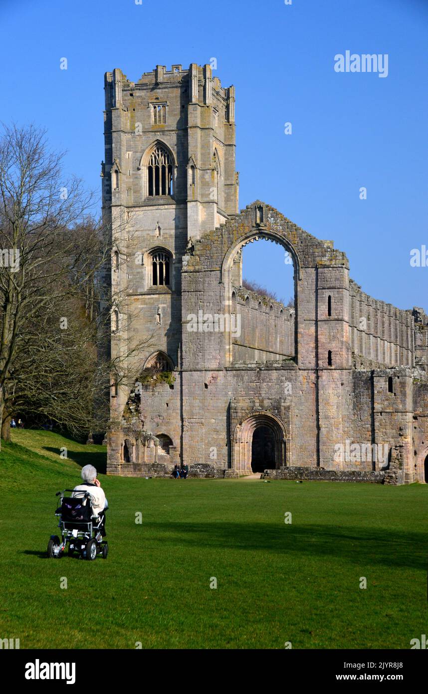Woman in Wheelchair Looking at the Ruins of the Chapel & Bell Tower at