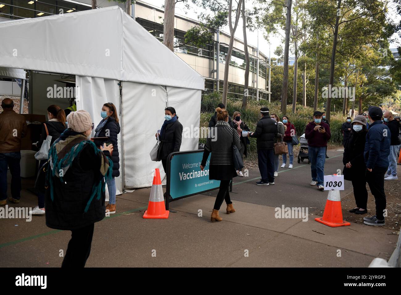 People are seen lining up at the Mass vaccination hub at Olympic Park ...