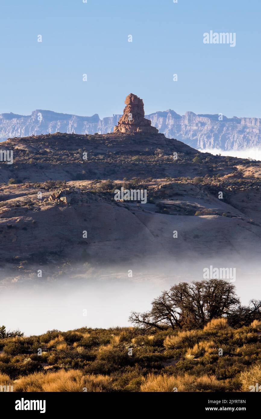An unnamed Entrada sandstone rock spire with fog in a winter