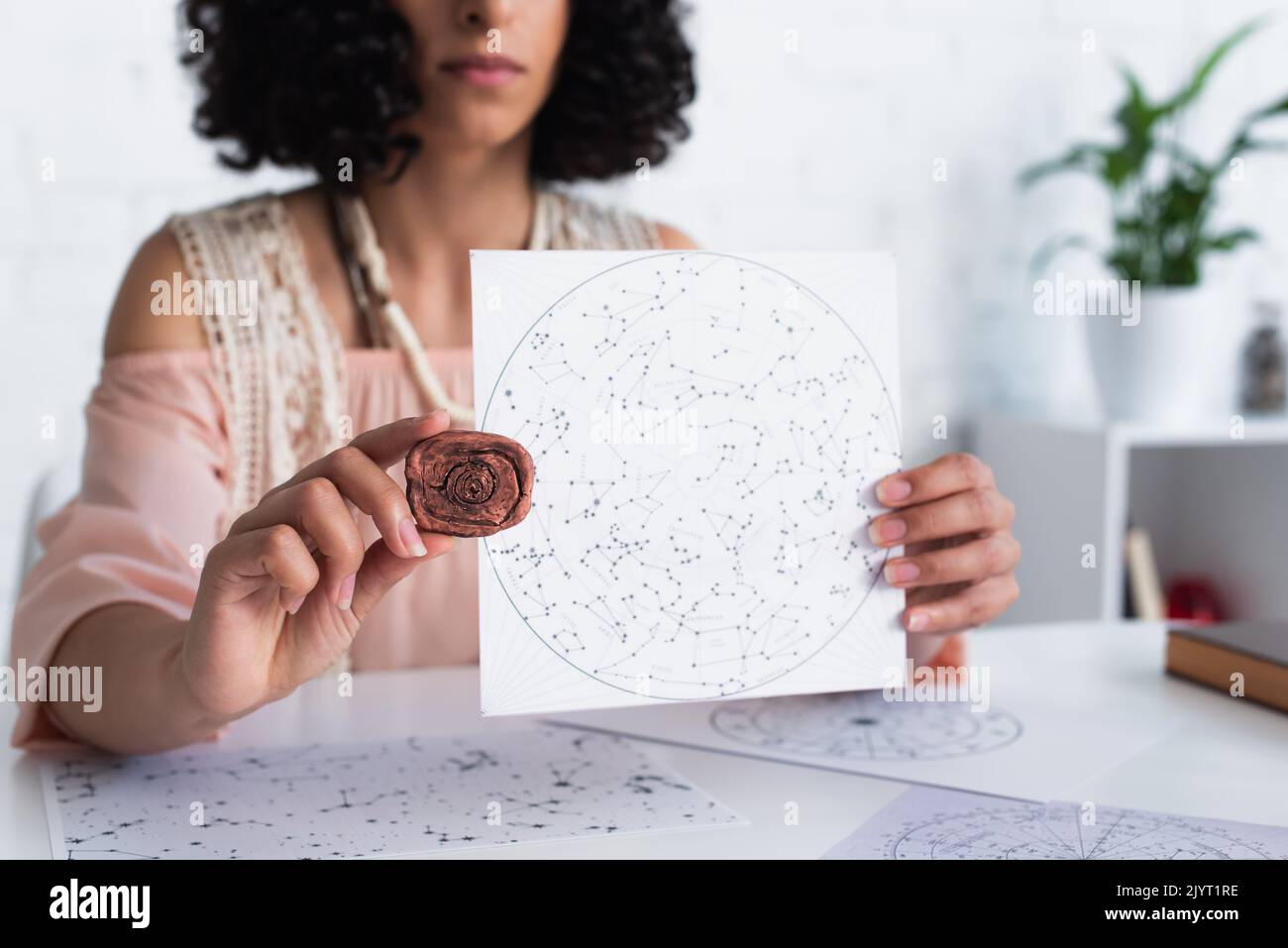 Constellation Runes partial view of oracle holding clay rune and constellations map Stock ...