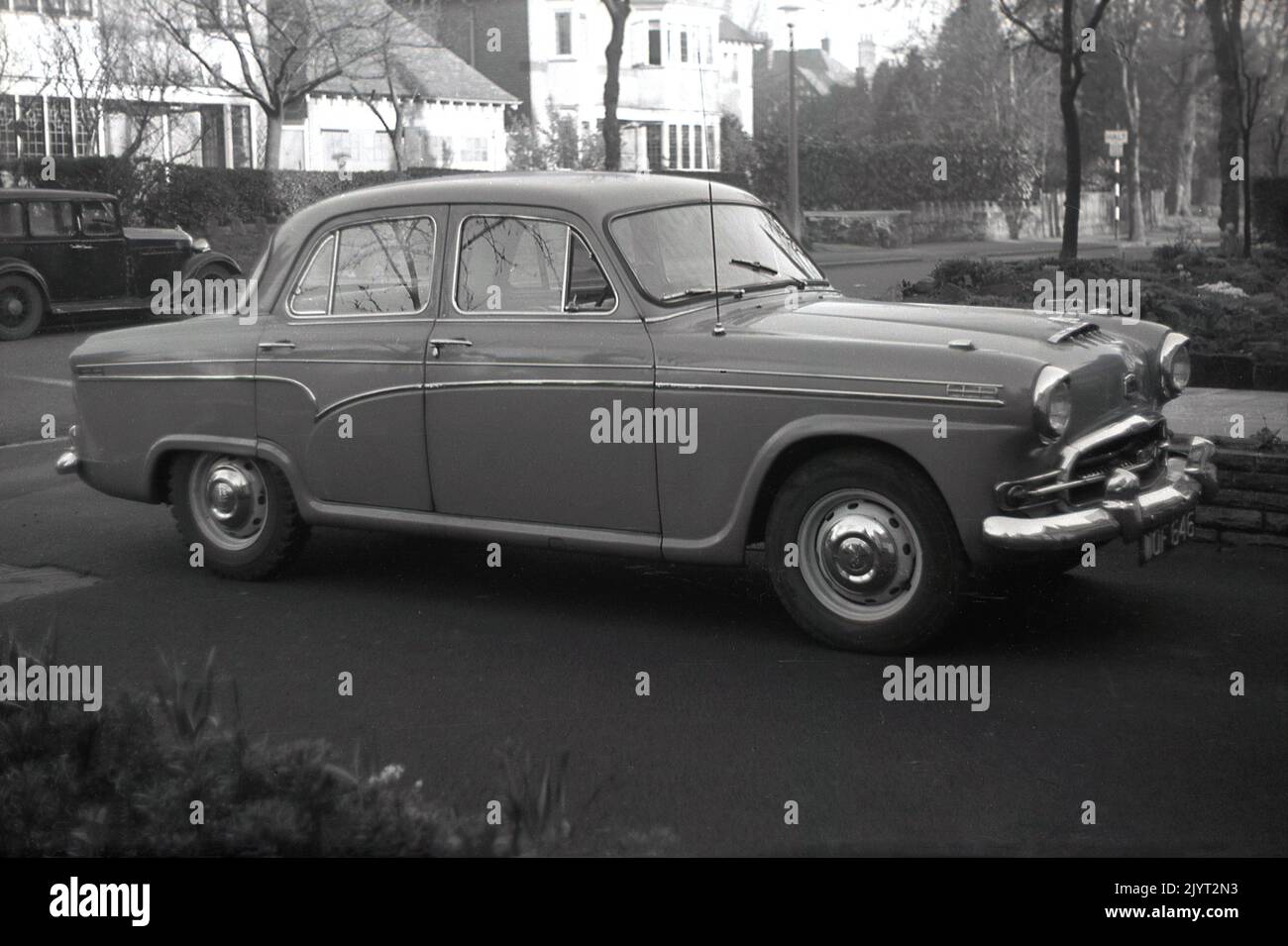 1950s, historical, a motorcar of the era, an Austin Cambridge, an A55, parked on a driveway, off a suburban street, England, UK. A pre-war car is parked in the street behind. The Austin Cambridge was produced in Cowley, Oxford, England, over several generations and in different models, from 1954 to 1971, Stock Photo