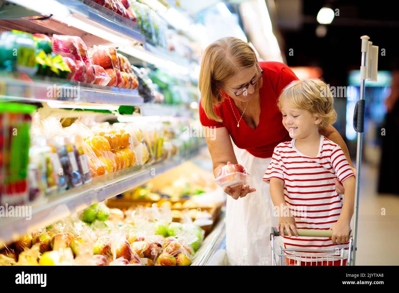 Shopping with kids. Mother and child buying fruit in supermarket. Mom