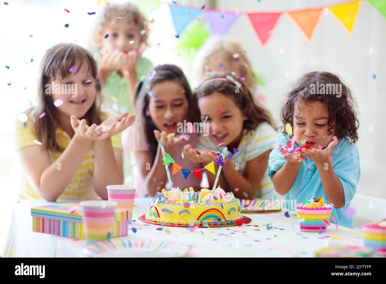 Kids birthday party. Children celebrate with colorful cake and gifts