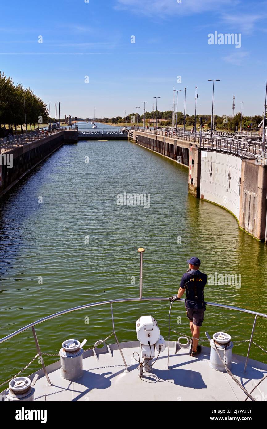 Veere, Netherlands - August 2022: Crew member on the bow of a river cruise ship as it enters the canal lock near the town Stock Photo