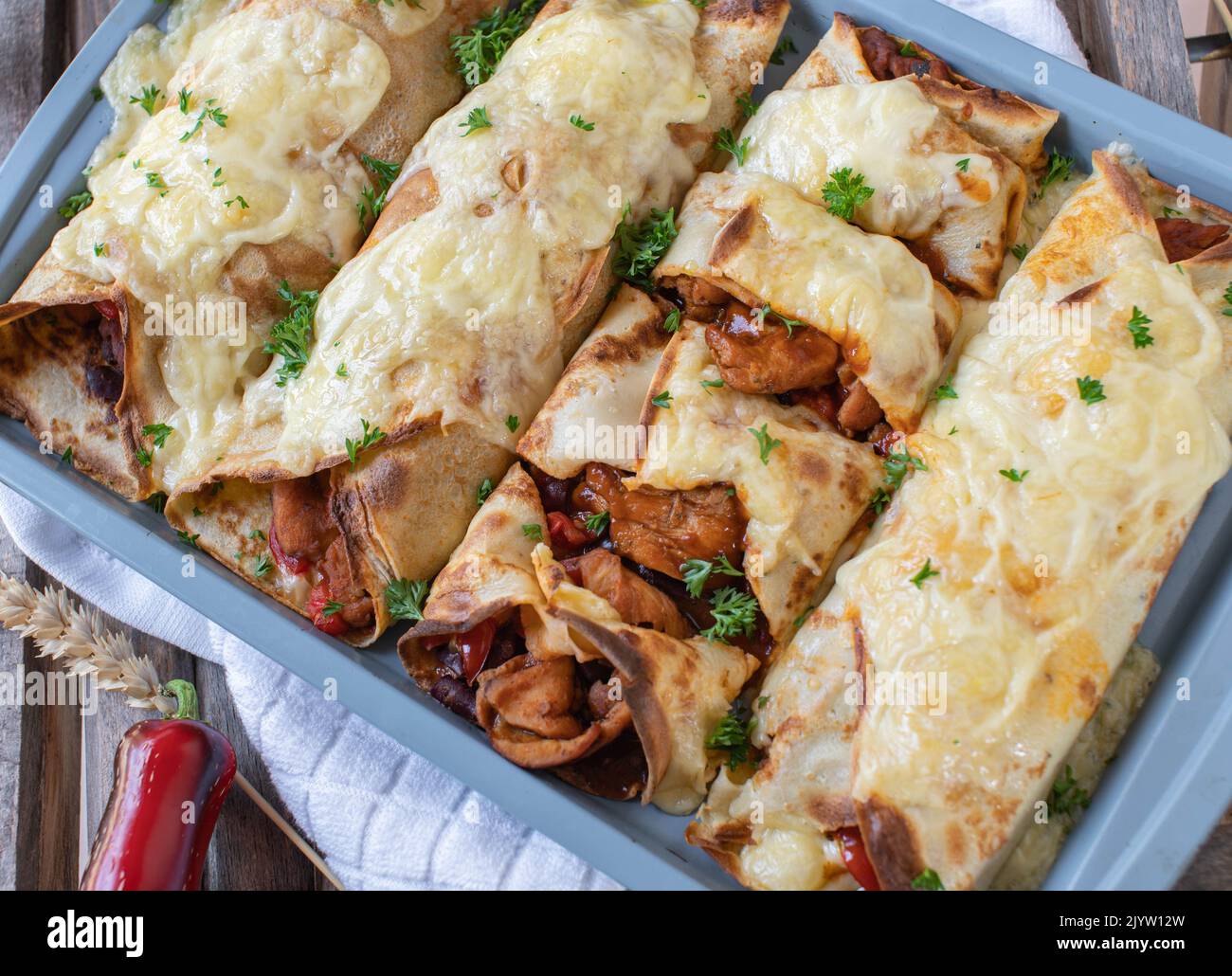 Pancakes with spicy chicken, bean, vegetable filling and cheese topping Stock Photo