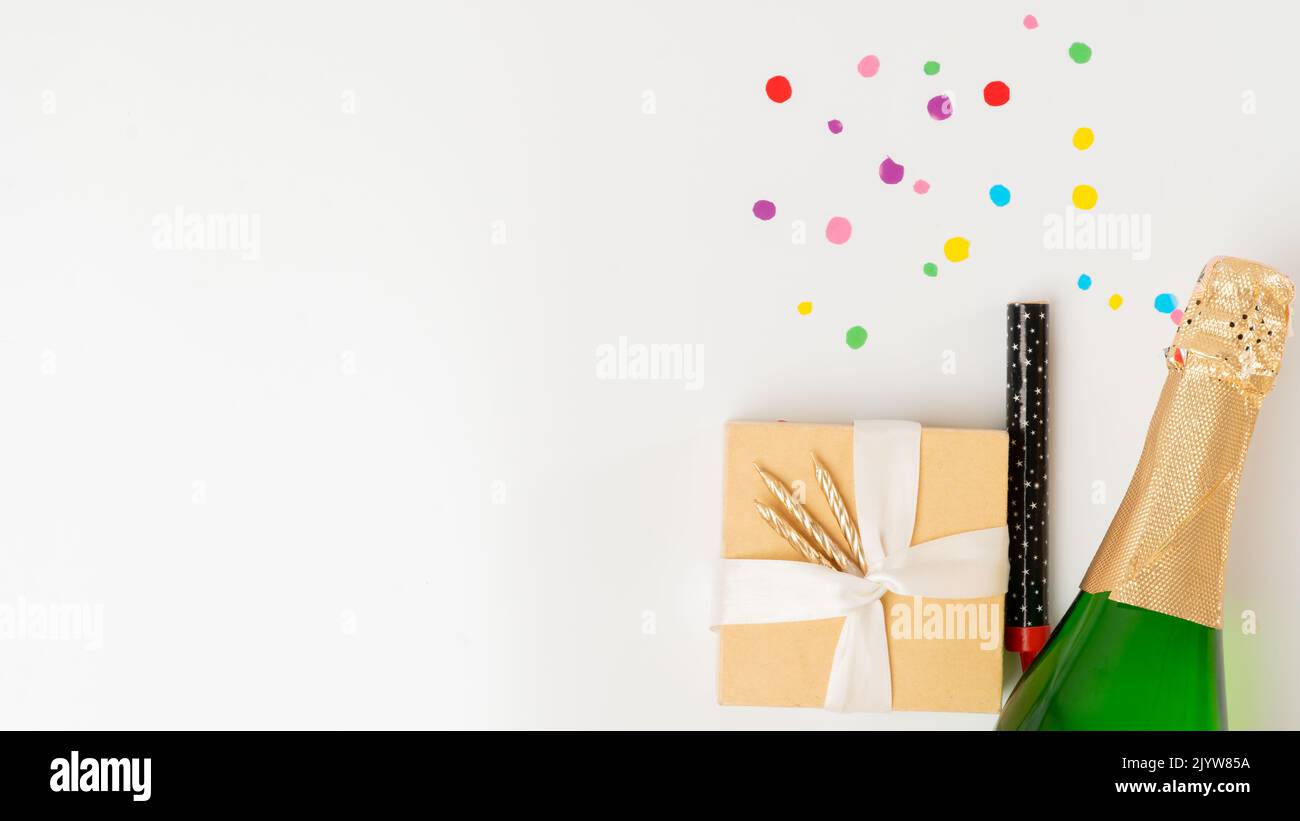 New Year's set - a gift, champagne and a cracker on a white background with a place for text Stock Photo
