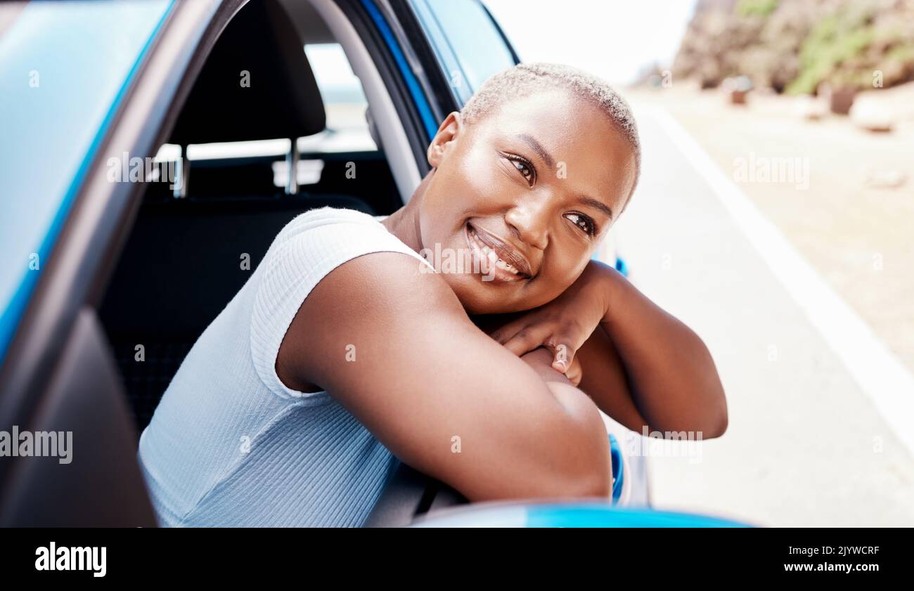 Happy woman, road trip and travel with a young black female leaning over car window while sitting in her vehicle during summer. Happy and beautiful Stock Photo