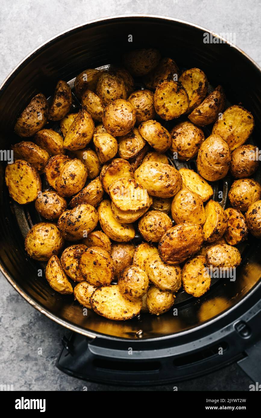 Overhead spicy Yukon Gold potatoes in an air frier Stock Photo
