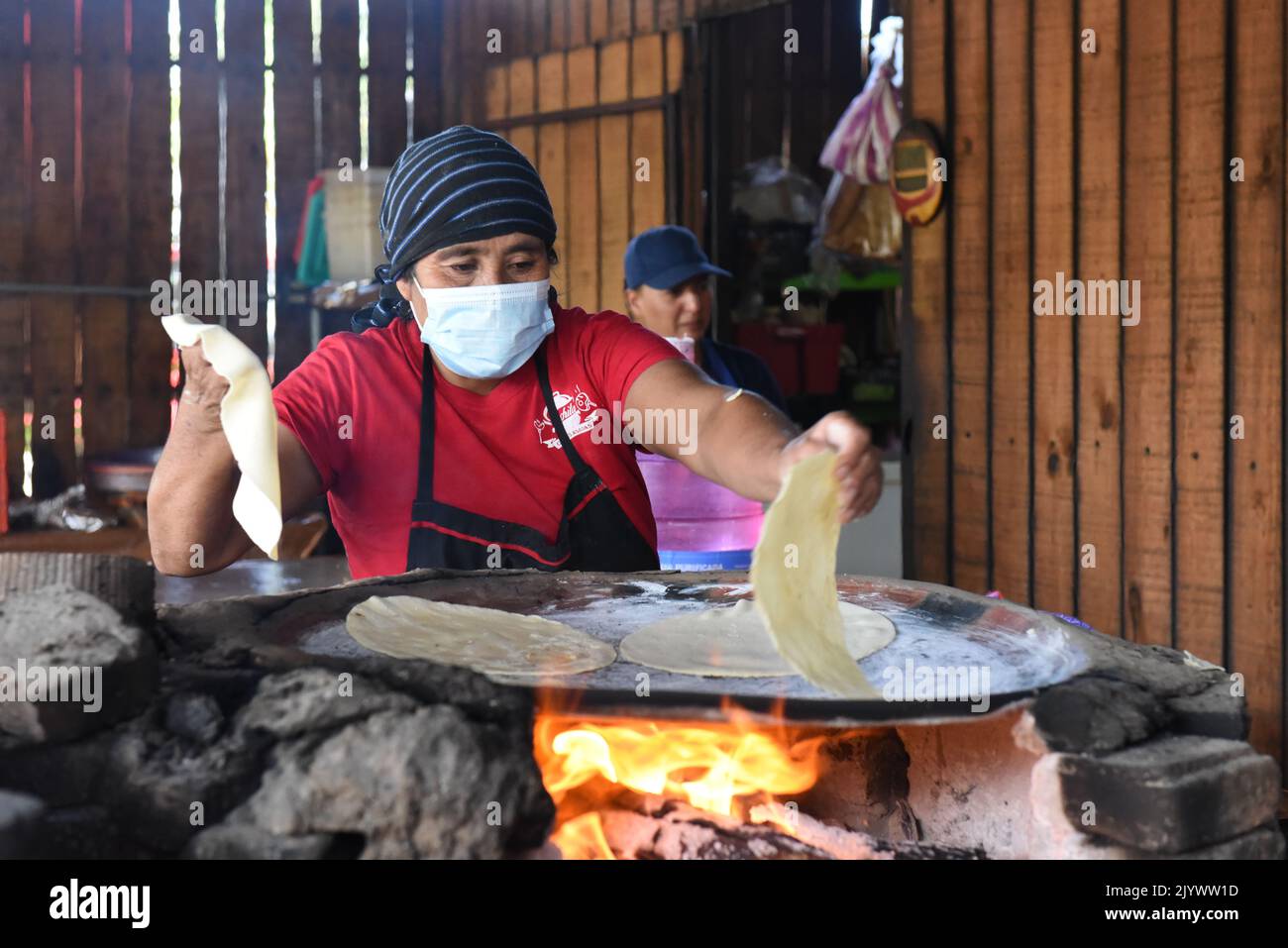 Woman cooking Tlayudas on an wood-fire, Oaxaca México Stock Photo