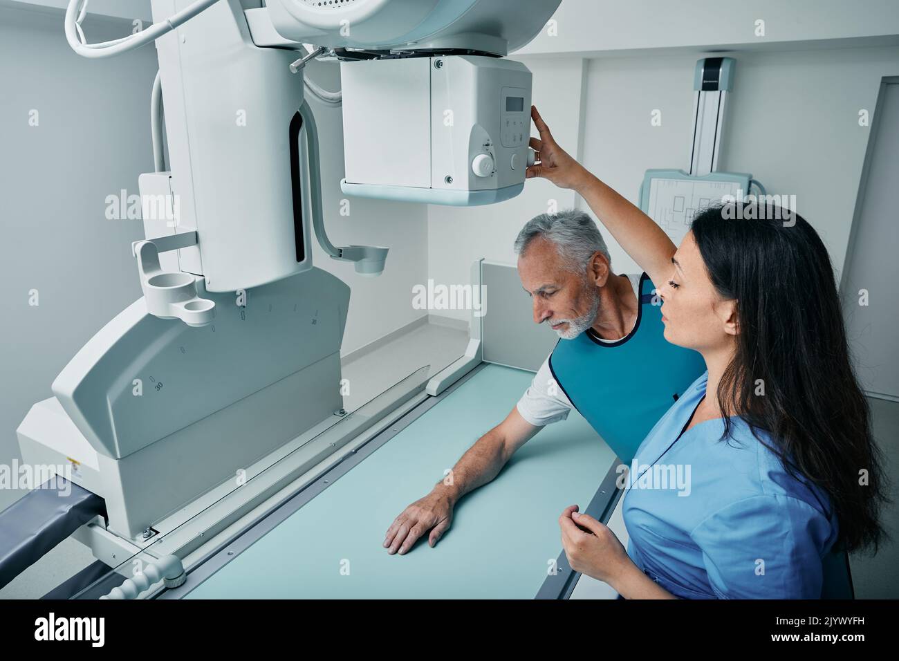Radiologist doing Xray of male patient's hand on modern Xray machine