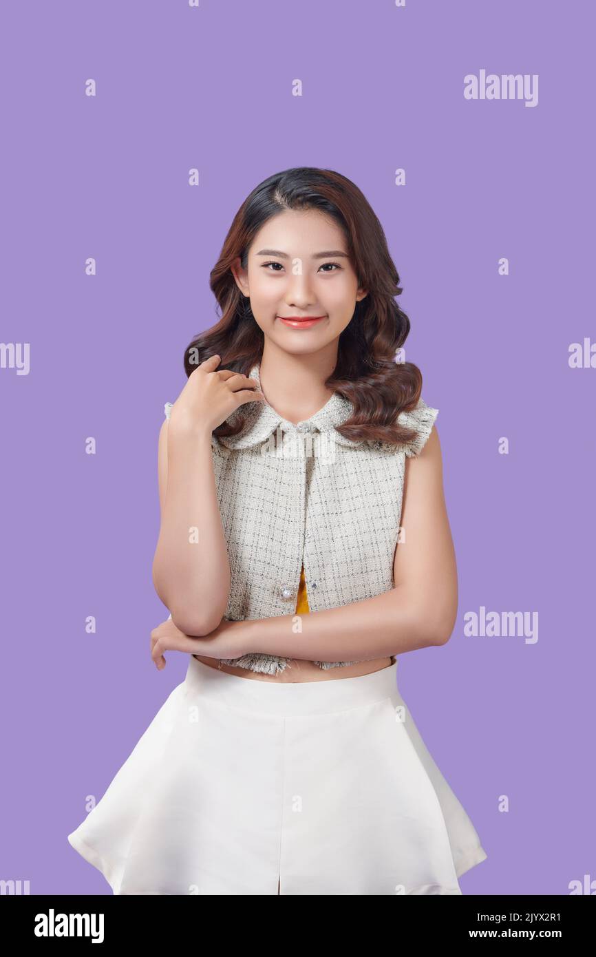 Young asian woman isolated on purple background making doubts gesture looking side Stock Photo