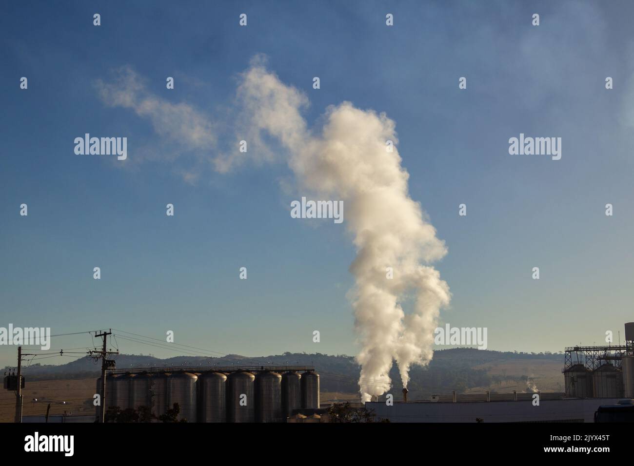 Goiânia, Goias, Brazil – December 25, 2021: Smoke coming out of the factory chimney. Air pollution from smoke coming out of factory chimneys. Stock Photo