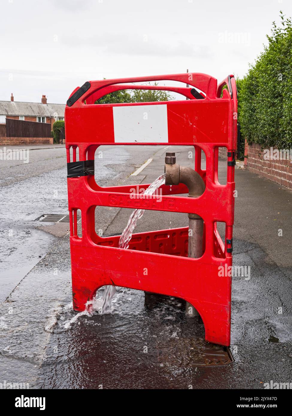Water flowing freely into a UK street during a time of hosepipe bans in 2022 Stock Photo