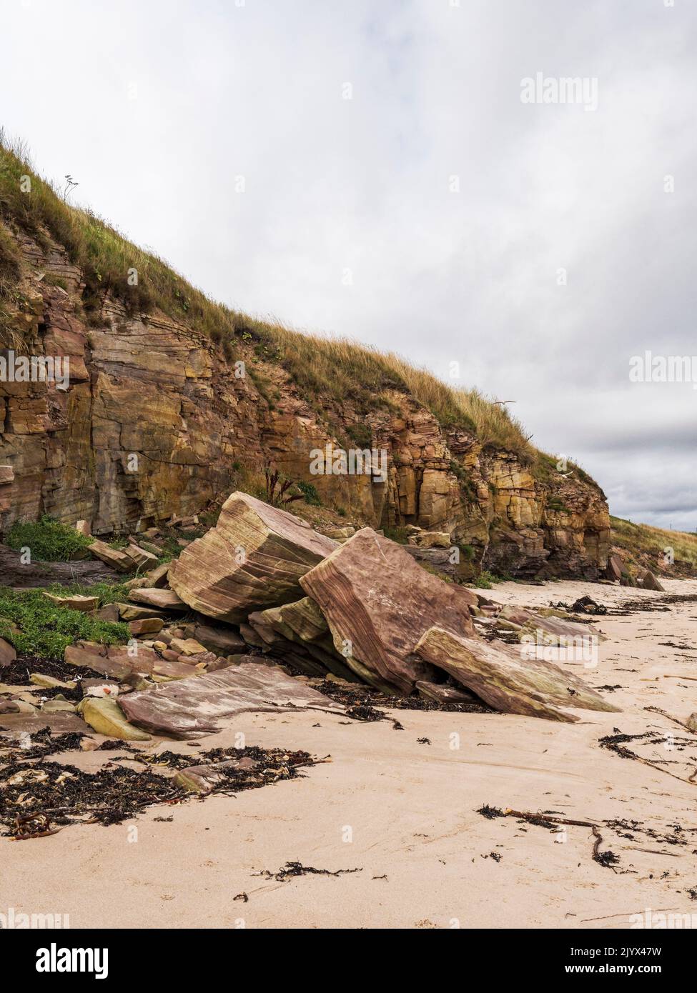 Coastal erosion illustrated by fallen sandstone cliffs at Cresswell beach in Northumberland, UK Stock Photo