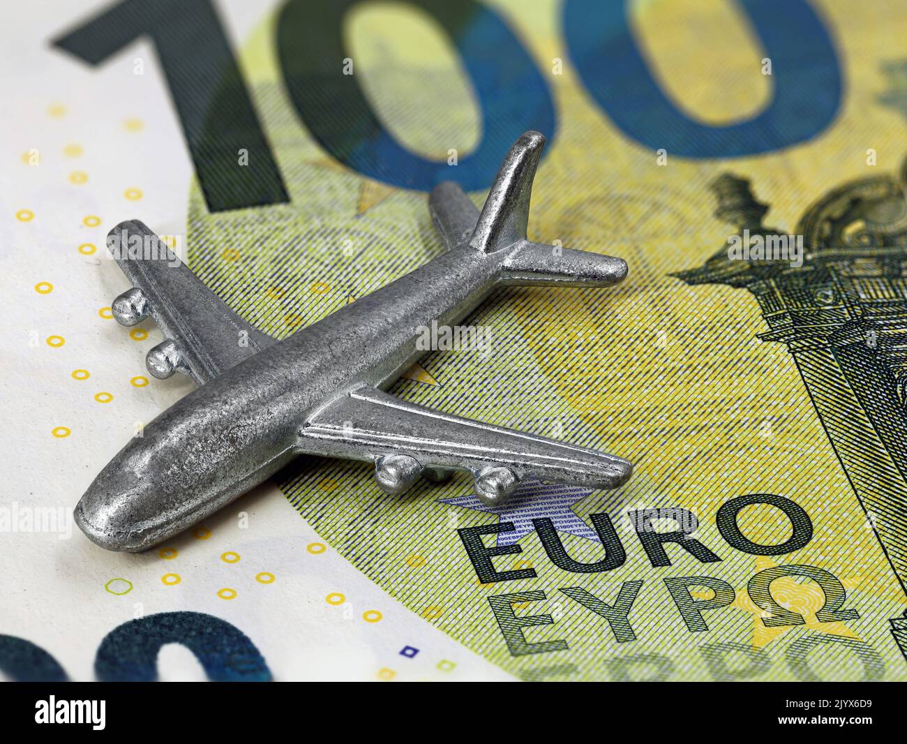 close up of miniatur airplane on 100 euro banknote, rising prices for flights or travel cost concept Stock Photo