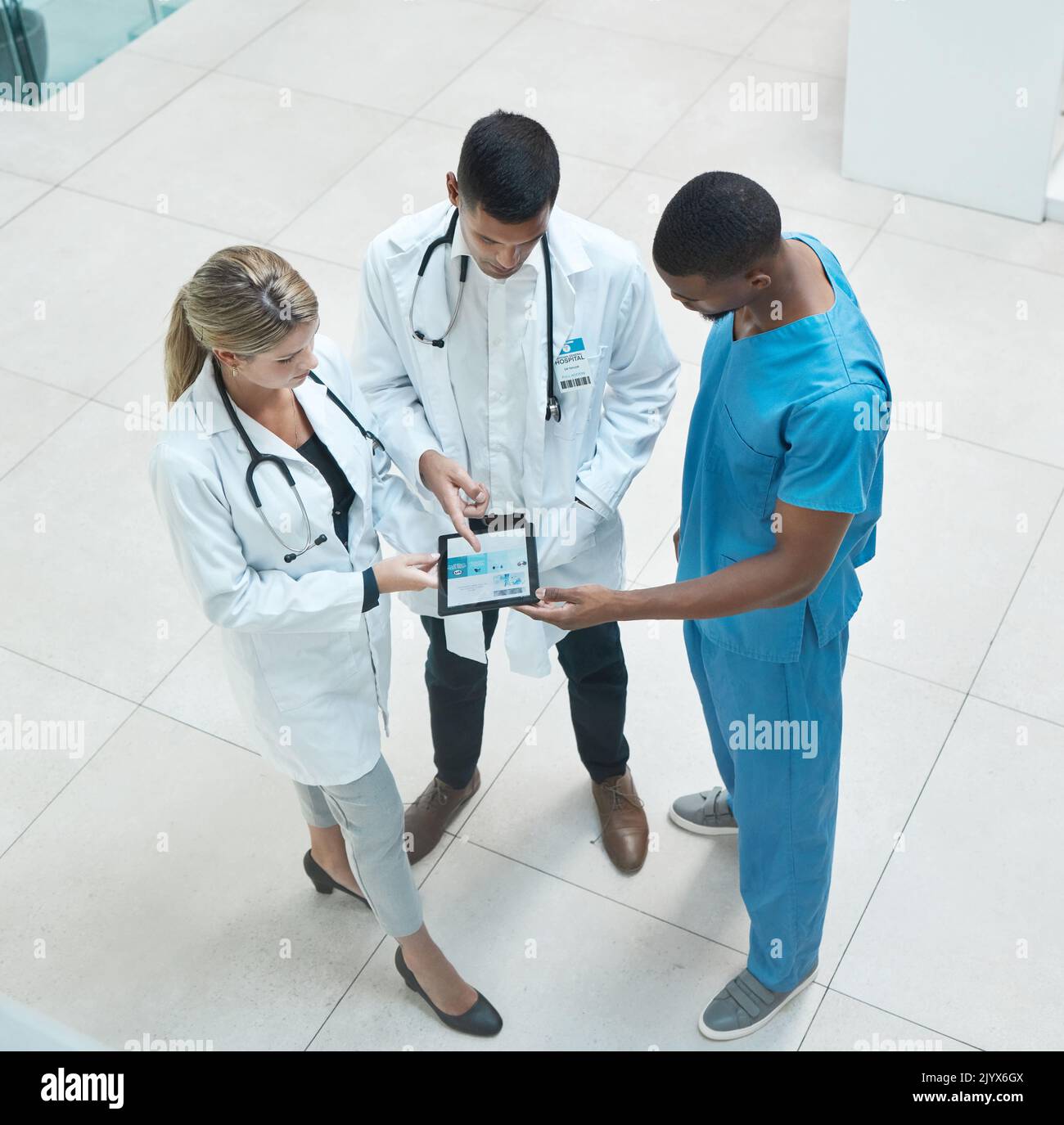 Group of doctors working on digital tablet while standing in the