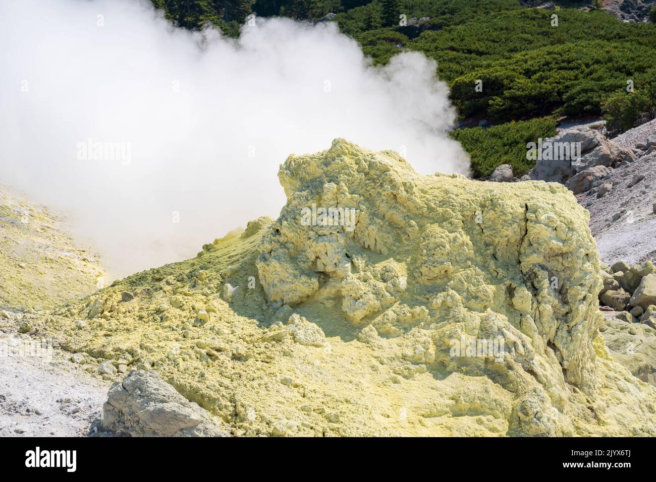 smoking solfatara among sulfur deposits on the slope of the volcano Stock Photo