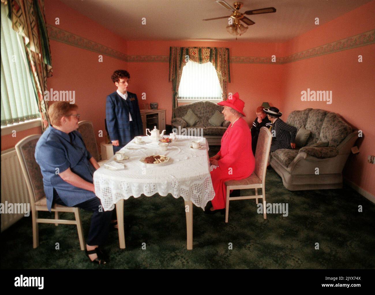 File photo dated 07/07/99 of Queen Elizabeth II joining Mrs Susan McCarron (front left), her ten-year-old son, James and Housing Manager Liz McGinniss for tea in their home in the Castlemilk area of Glasgow. The Queen died peacefully at Balmoral this afternoon, Buckingham Palace has announced. Issue date: Thursday September 8, 2022. Stock Photo