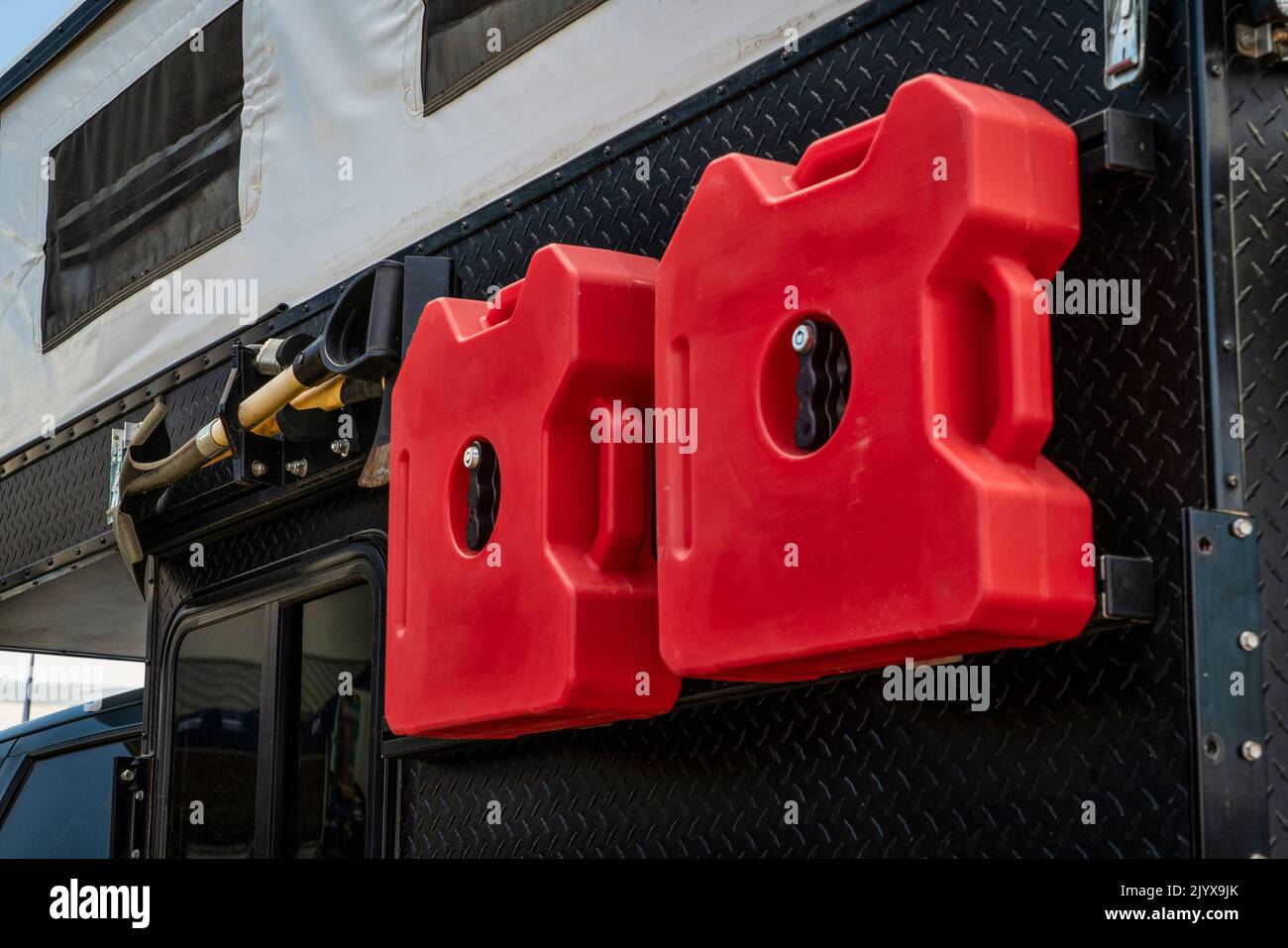 Gas containers, shovel and ax mounted on a camper side, camping and