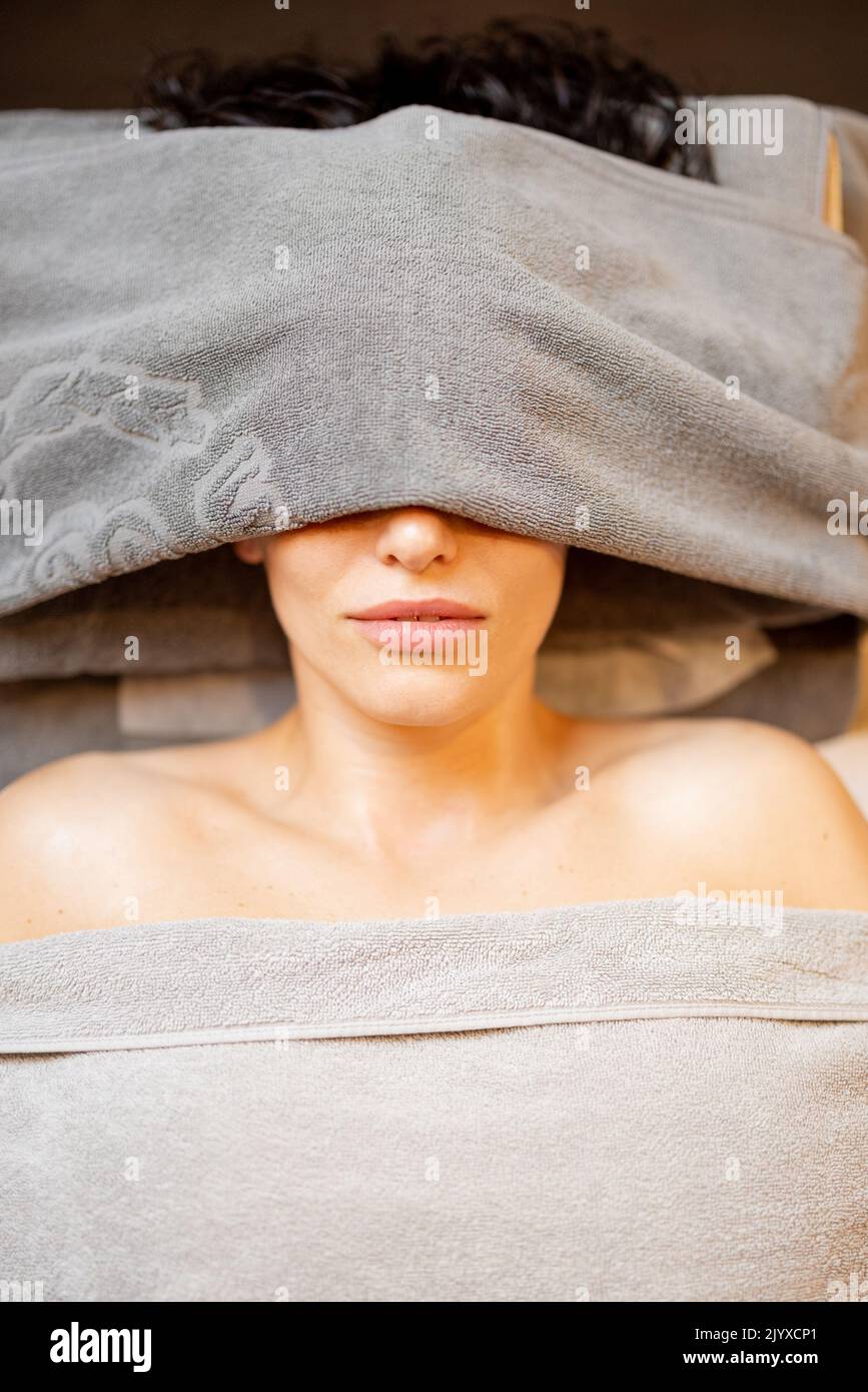Portrait of a woman lying covered with towels and waiting for a massage, view from above Stock Photo