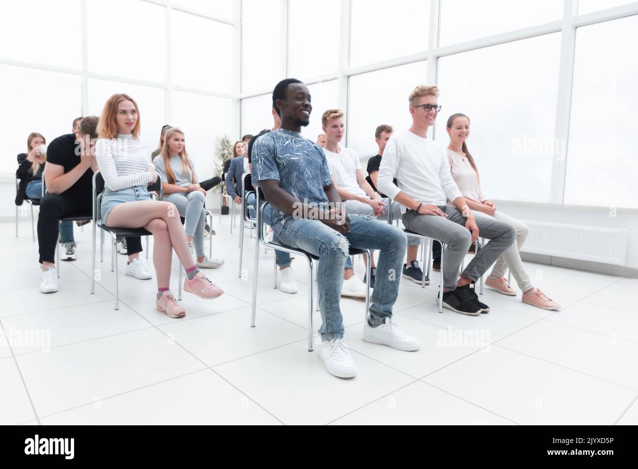 group of diverse young people sitting in a conference room Stock Photo ...