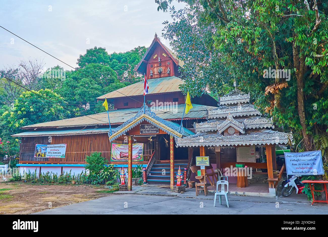 The vintage wooden temple of Wat Klang, surrounded with lush shady trees, Pai, Thailand Stock Photo