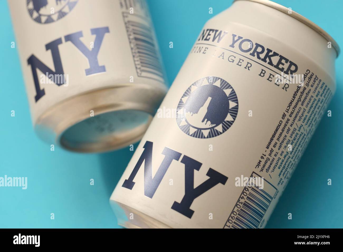 TERNOPIL, UKRAINE - JULY 18, 2022 Two cans of New Yorker fine lager beer with original logo and design on blue background Stock Photo